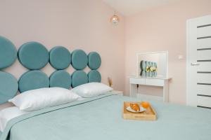 a bed with a blue headboard and a tray of food on it at Motława River Old City Gdańsk Apartment by Renters in Gdańsk