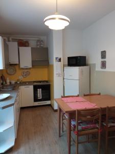 a kitchen with a table and a kitchen with a refrigerator at Casetta gialla in Pieve di Cadore