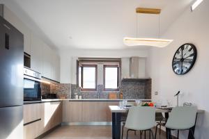 a kitchen with a table and a clock on the wall at Riviera Vista Luxury Homes in Dhrámia
