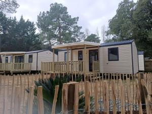 Une rangée de mobile homes derrière une clôture dans l'établissement Camping Les Maraises, à Saint-Martin-de-Ré