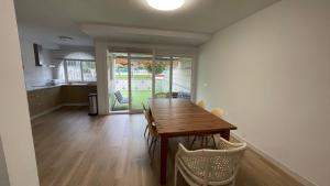 a kitchen and dining room with a wooden table and chairs at El Paraíso Retamar in Almería