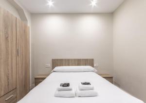 a bedroom with a large white bed with two towels at Biator apartment by People Rentals in Basauri