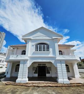 a white house with a blue sky in the background at Luna Hotel by Moonknight in George Town