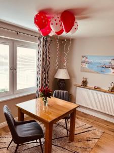 uma sala de jantar com uma mesa e balões vermelhos e brancos em Poppy Annex em Wellow
