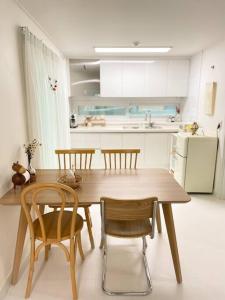 cocina con mesa de comedor de madera y sillas en Yeomi Stay en Suwon