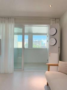 een woonkamer met een bank en een groot raam bij Yeomi Stay in Suwon