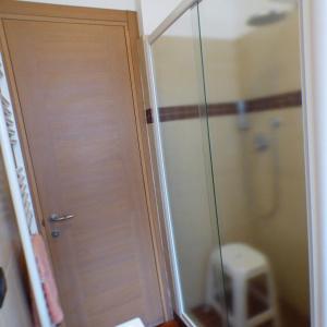 a bathroom with a shower and a door to a toilet at Girasoli in Pisa +3 photos