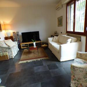 a living room with a white couch and a tv at Girasoli in Pisa