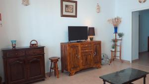 佩拉的住宿－A Casa dos Avós，客厅配有木柜上的电视