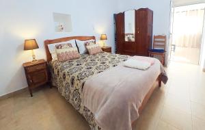 a bedroom with a large bed and two night stands at A Casa dos Avós in Pêra