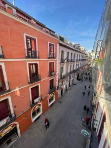 a city street with buildings and people walking down a street at Hostal Oliver in Madrid