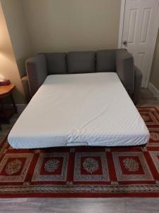 een bed op een bank in een kamer bij Appartement Cartier in Longueuil