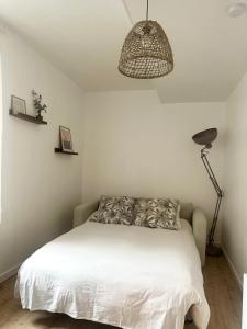 1 dormitorio con 1 cama blanca y 1 lámpara en Appartement T2 hyper centre, en Dieppe
