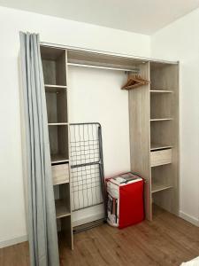 Habitación con armario y caja roja. en Appartement T2 hyper centre, en Dieppe