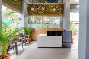 a lobby with a table and chairs and plants at Treebo Trend Raana Encore - Near Magarpatta in Pune