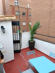 un balcón con mesa, sillas y una planta en El Mirador de la Azucena en Guadalajara