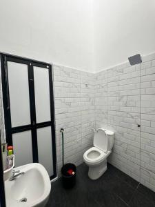 a bathroom with a white toilet and a sink at One Mama’s Guest House in Kuala Selangor