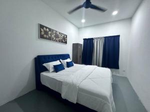 a bedroom with a bed with a ceiling fan at One Mama’s Guest House in Kuala Selangor