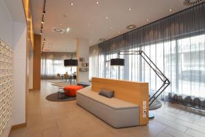 a lobby with a couch and a large window at SMARTments business Wien Hauptbahnhof - Serviced Apartments in Vienna