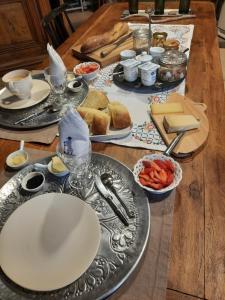une table en bois avec des assiettes de nourriture dans l'établissement Au Bonheur d'Alphonse, à Lusignan-Petit