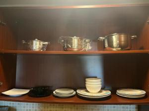 a wooden shelf with dishes and pots and pans at هافانا المارينا Apartment in King Abdullah Economic City