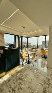ナポリにあるPOETICA BOUTIQUE SKY HOTELのテーブルと椅子、窓が備わる客室です。