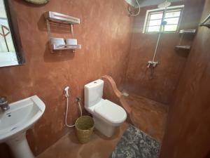 a bathroom with a toilet and a sink at Oasis Bungalows in Jambiani