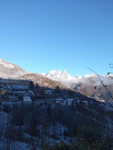a view of a town with snow covered mountains at Casetta gialla in Pieve di Cadore