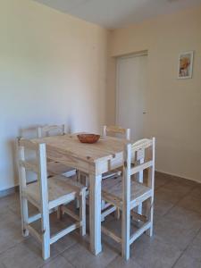 a wooden table with chairs and a bowl on it at Nuevo Departamento Leona - EXCELENTE PROPIEDAD A ESTRENAR in Paso de los Libres