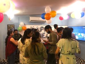 a group of people standing in a room with balloons at Stayvilla Hostel in Mumbai