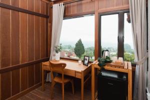 a home office with a desk and a window at Girihill Farmhouse in Munduk