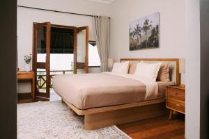 a bedroom with a large bed and a window at Girihill Farmhouse in Munduk