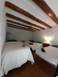 a room with three beds with white sheets at Alojamiento Compartido En Rambla De Cataluña in Barcelona