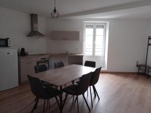 - une cuisine avec une table et des chaises en bois dans l'établissement La Résidence du Canal de Bourgogne, à Montbard
