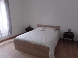 ein Schlafzimmer mit einem großen Bett mit zwei Nachttischen in der Unterkunft La Résidence du Canal de Bourgogne in Montbard