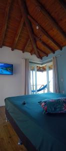 a bedroom with a blue bed with a window at Chalé em Torres Recanto Estelar in Torres