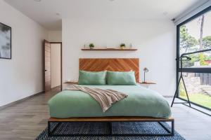 1 dormitorio con 1 cama verde grande y cabecero de madera en La Fábrica #7 Averly en Valle de Bravo