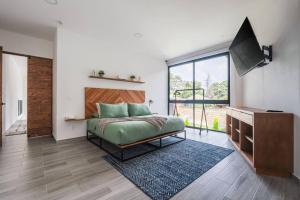 una camera da letto con un letto e una grande finestra di La Fábrica #7 Averly a Valle de Bravo Altre 68 foto