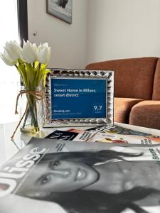 a laptop on a table with a newspaper and a magazine at Sweet Home in Milano smart district in Milan