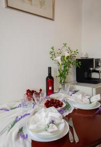 - une table avec des assiettes de nourriture et une bouteille de vin dans l'établissement Casa Ilenia al Belvedere Hanbury, à Bordighera