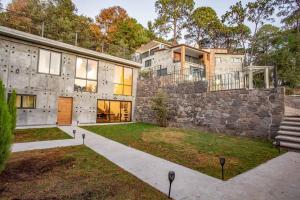 una grande casa in pietra con un muro di pietra di La Fábrica #7 Averly a Valle de Bravo