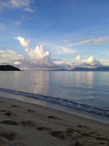a beach with the ocean and clouds in the sky at Villa LunaSole Samui in Koh Samui 