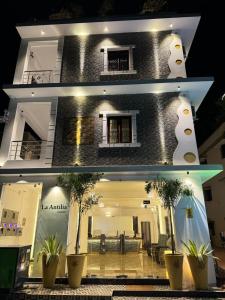 two pictures of a building with plants in front of it at La Antilia Luxury in Puducherry