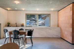 eine Küche mit einem Tisch und Stühlen sowie einem Fenster in der Unterkunft Lena Dolomites Suite in Villnöß