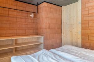 Zimmer mit einem Bett und einer Ziegelwand in der Unterkunft Lena Dolomites Suite in Villnöß