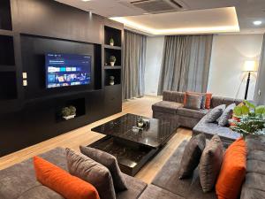 uma sala de estar com um sofá e uma televisão em Two bedroom suite, Gold crest Mall em Lahore