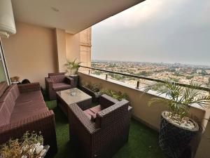uma varanda com cadeiras e mesas e vista para a cidade em Two bedroom suite, Gold crest Mall em Lahore