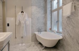 a white bathroom with a bath tub and a sink at Clas på Hörnet in Stockholm