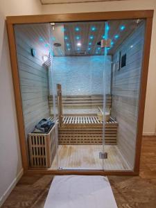 uma casa de banho com um chuveiro com um banco em NG SuiteHome - Lille l Tourcoing Winoc - Balnéo - Sauna - Netflix - Wifi em Tourcoing