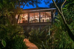 a house in the forest at night at The Jungle Oasis with heated pool in Nairobi